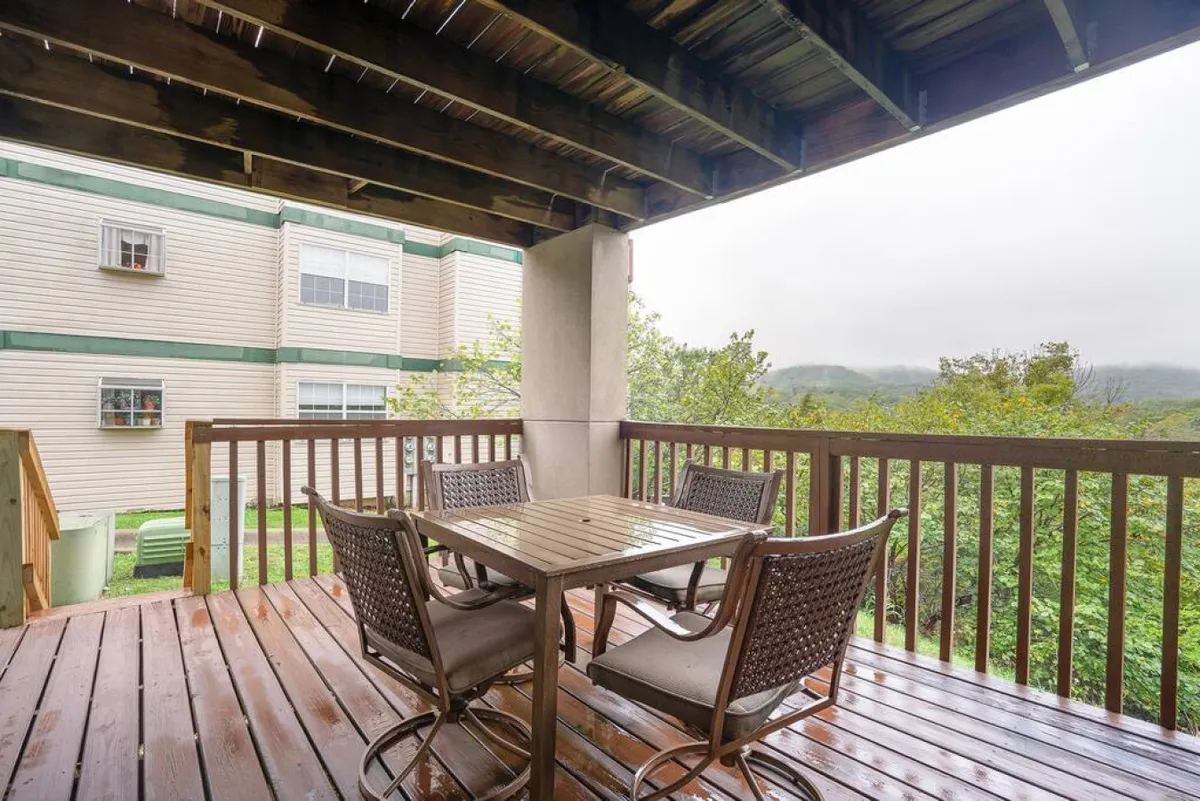 This image features an inviting wooden deck outfitted with a table and chairs, set amidst surrounding greenery. The scene exudes a sense of tranquility and offers a glimpse of sunrise views over the hills, suggesting the perfect spot for outdoor dining or relaxed gatherings.